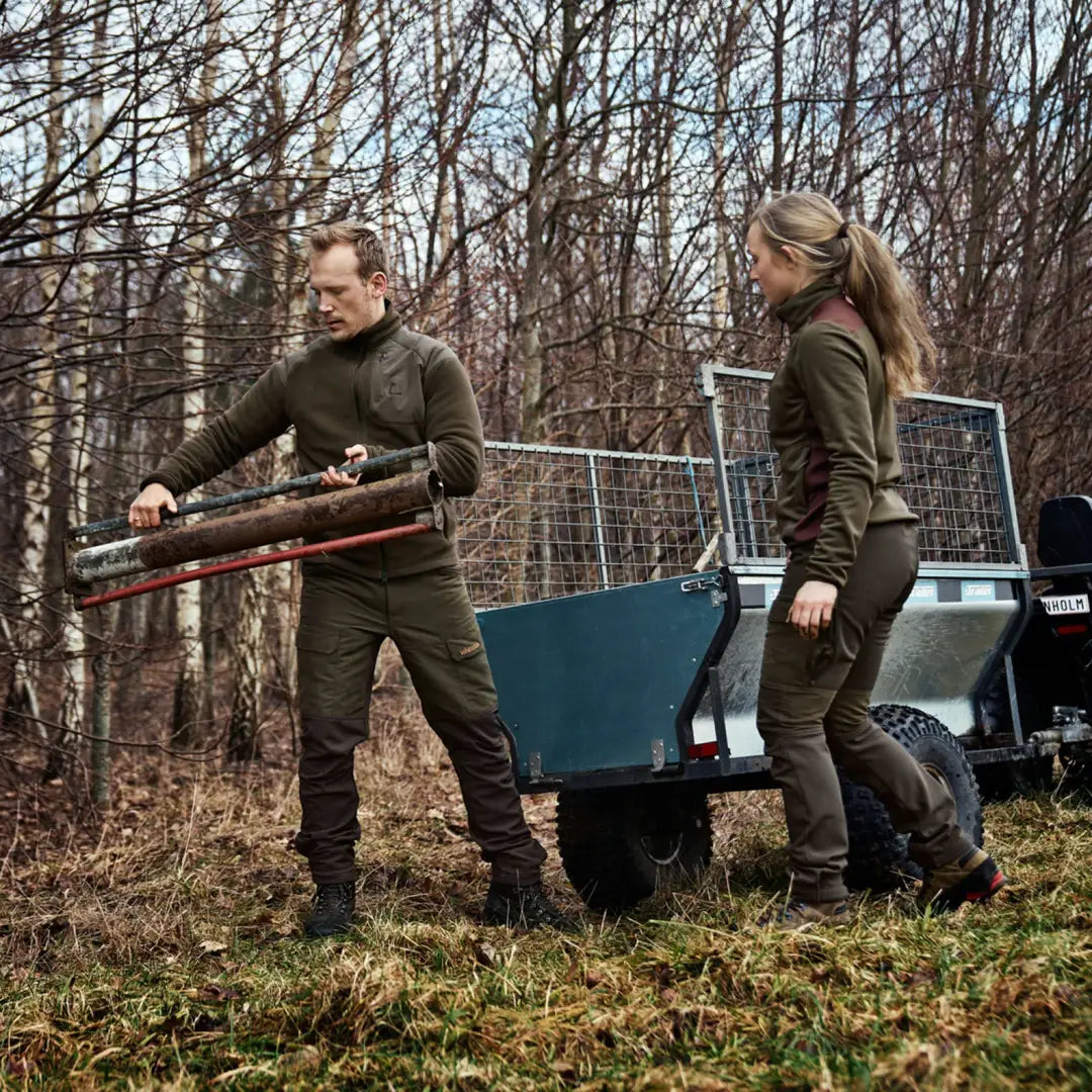 Two people in Scandinavian Trousers working outdoors with gardening tools