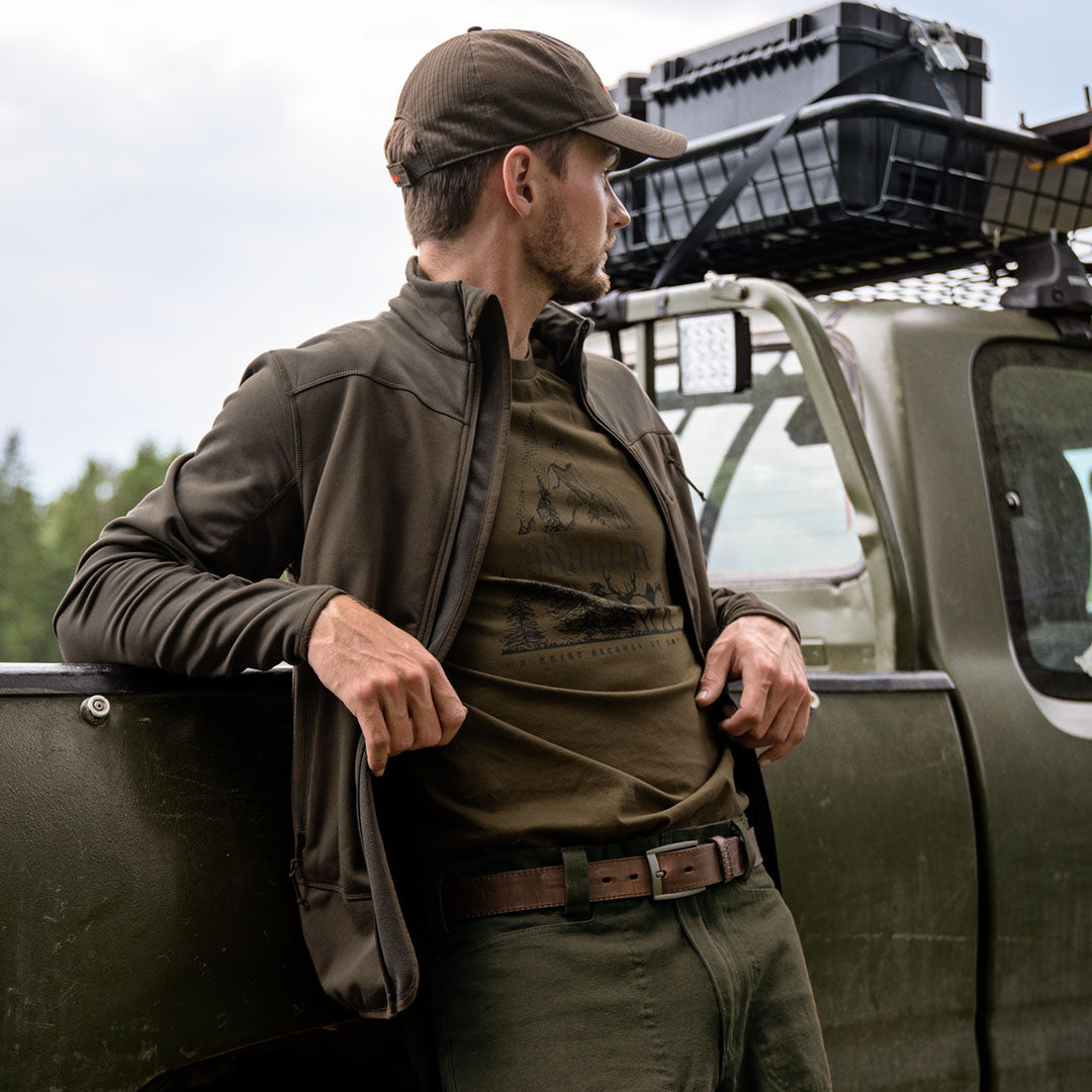 Man in outdoor clothing leaning on truck wearing Harkila Nature T-Shirt for hunting