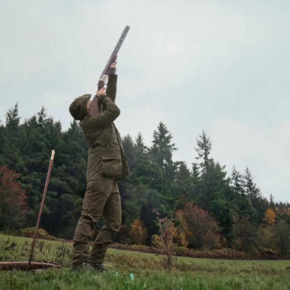 Hunter aiming a shotgun wearing the stylish Harkila Orton Packable Lady Jacket