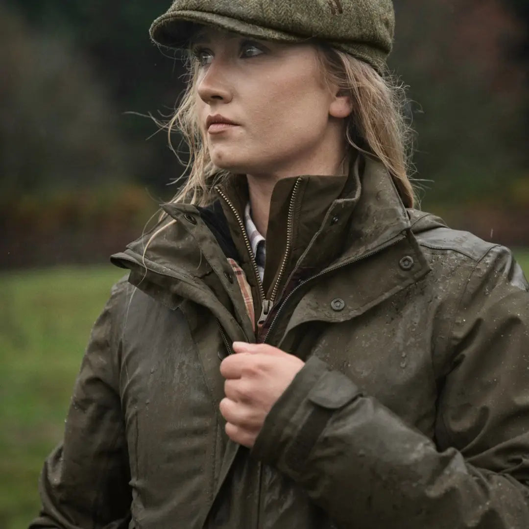 Woman in a green waxed Harkila Orton Packable Lady Jacket and tweed cap outdoors