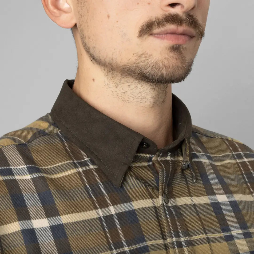 Plaid flannel shirt with brown collar and press button closure worn by a bearded guy