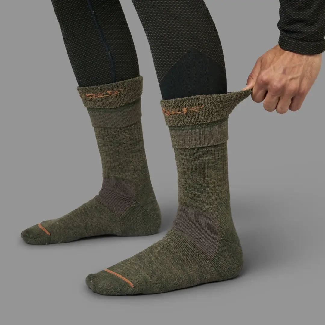 Pair of olive green Harkila Pro Hunter 2.0 Short Socks with fold-over cuffs in use