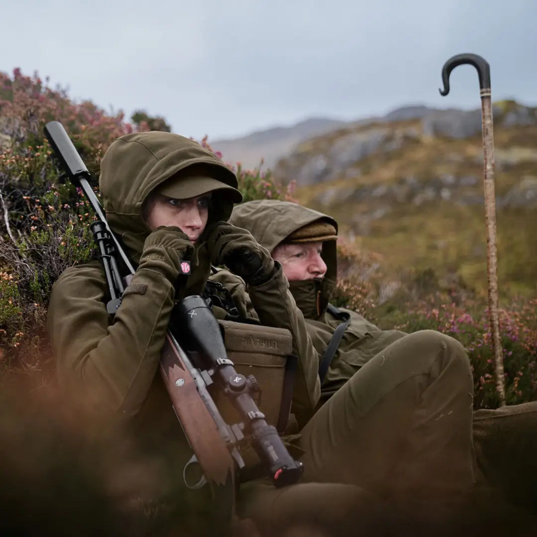 Two hunters in camo with rifle and walking stick in lush vegetation wearing Harkila Pro Hunter GTX