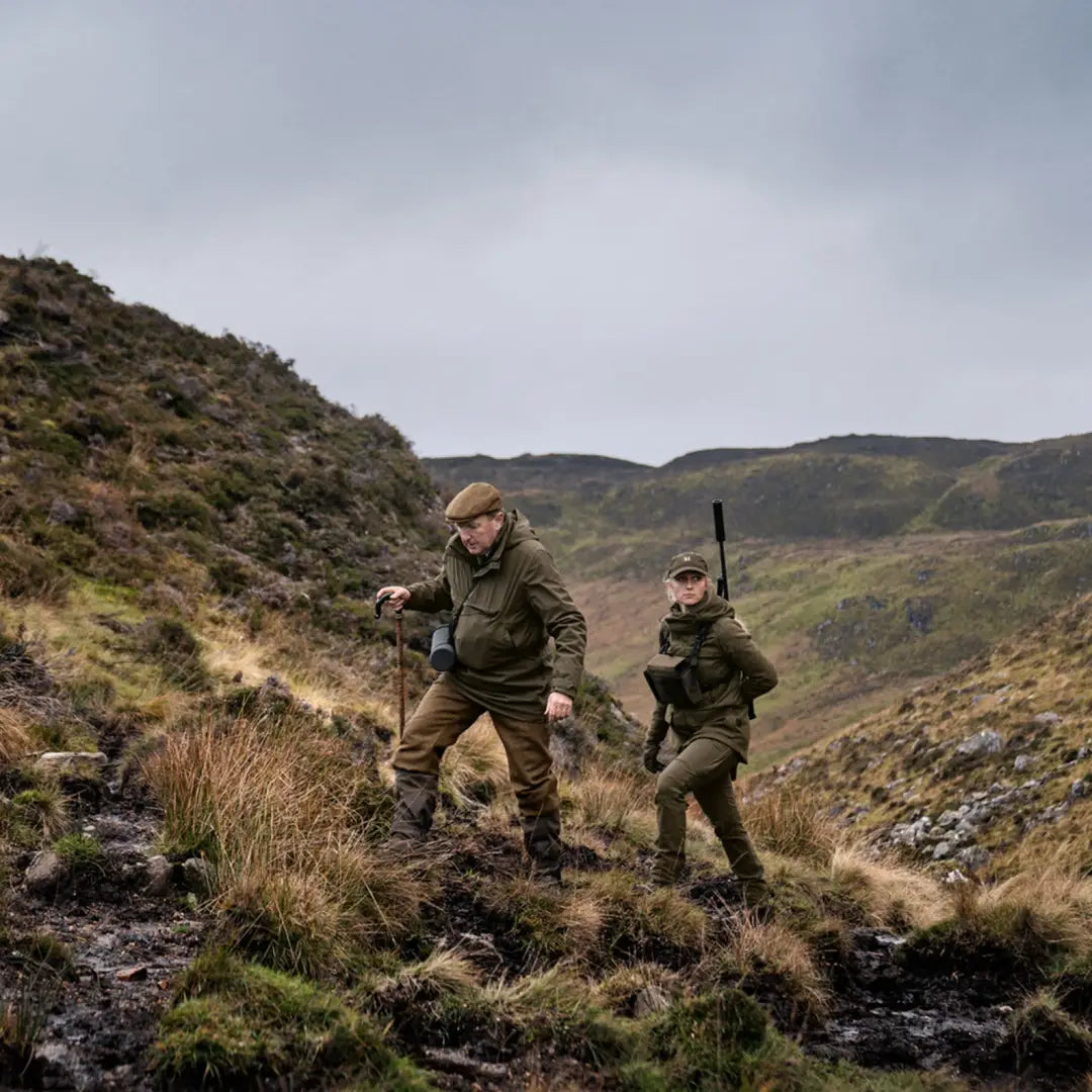 Two hunters in rugged terrain wearing Harkila Pro Hunter GTX Ladies Jacket with rifles