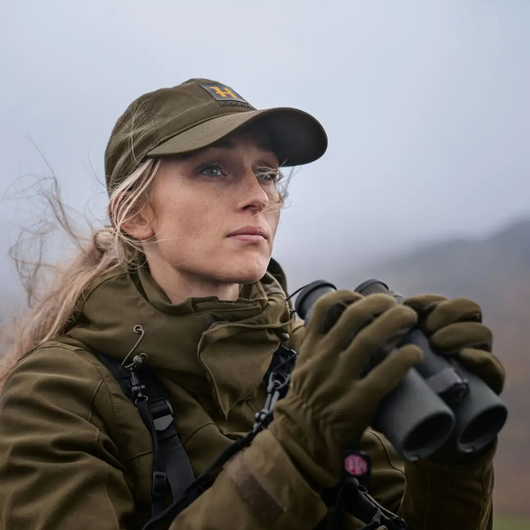 Woman in Harkila Pro Hunter GTX Ladies Jacket using binoculars outdoors