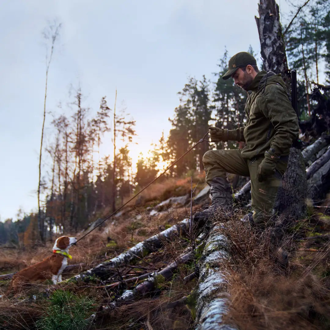 Soldier relaxing on a fallen tree wearing Harkila Pro Hunter GTX Jacket with elasticated drawstring