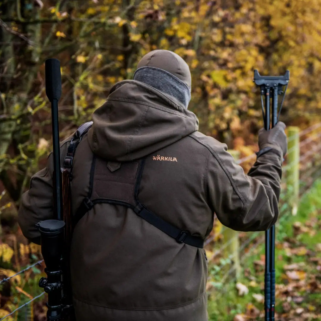 Person in a dark Harkila Pro Hunter Move 2.0 GTX Jacket with camera gear in woods