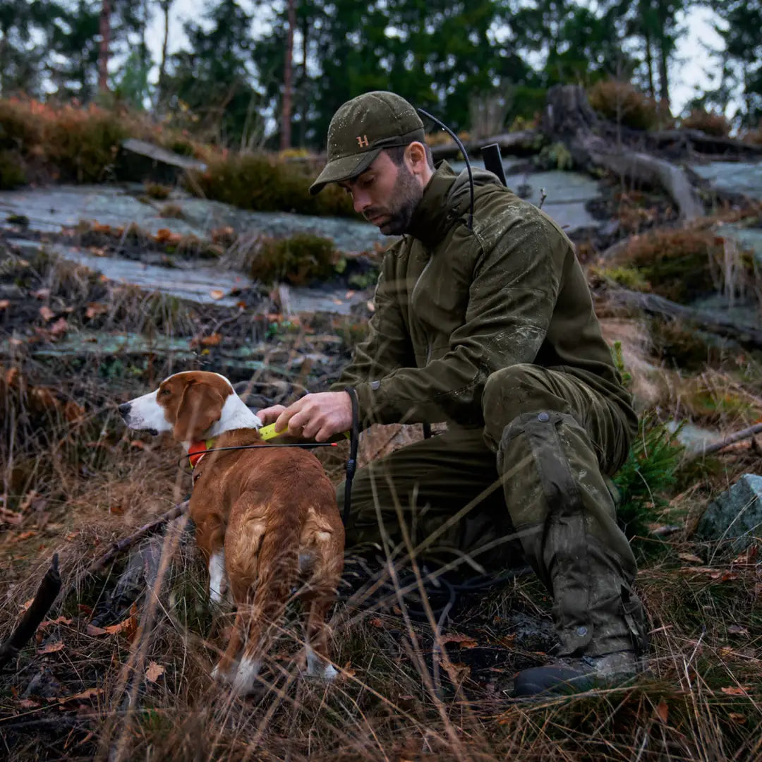 Hunter in camouflage gear with a dog in the wild featuring the Pro Hunter GTX Jacket