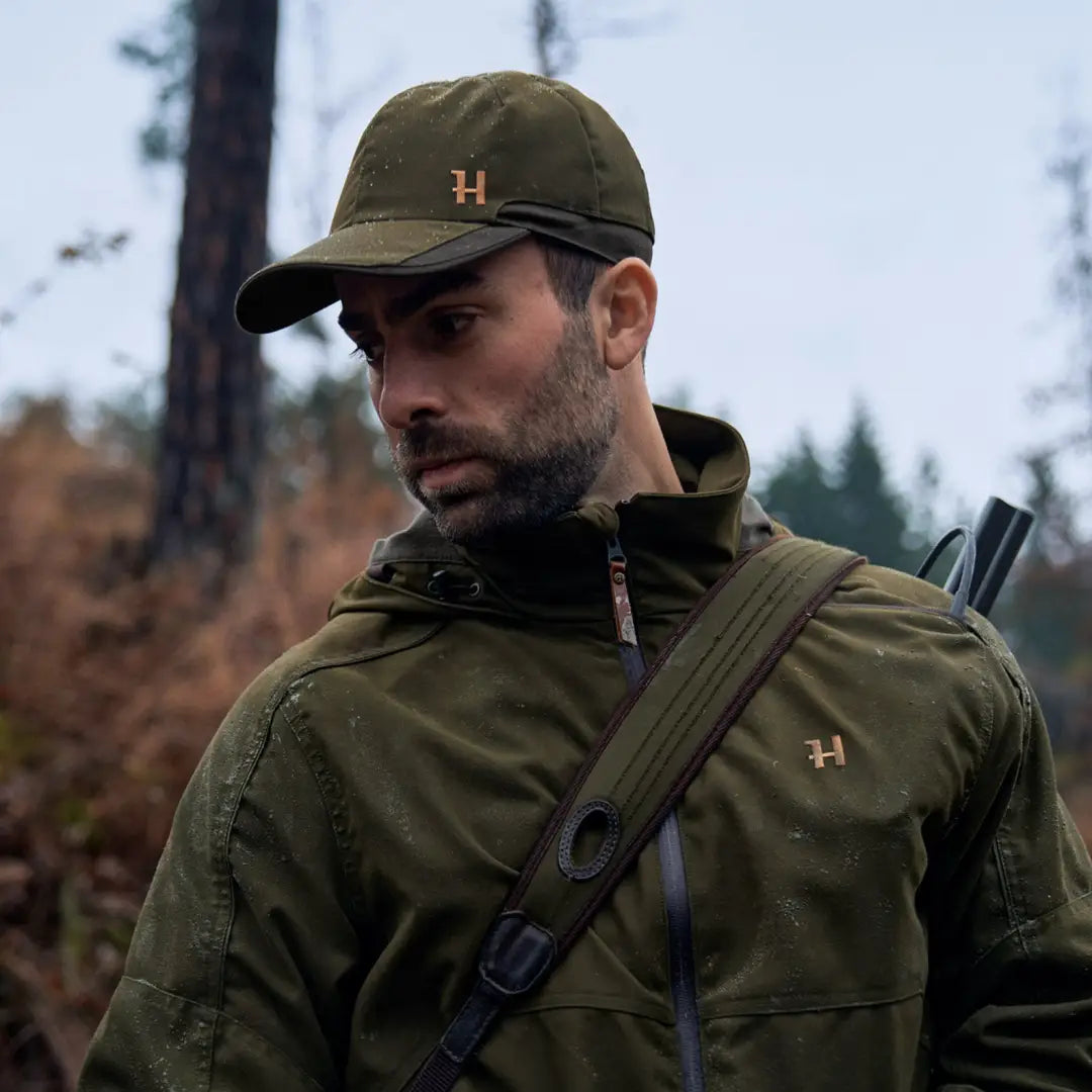 Man in green cap and jacket outdoors showcasing Harkila Pro Hunter Move 2.0 GTX Jacket