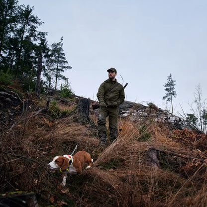 Hunter in Harkila Pro Hunter Move 2.0 GTX Jacket with dog on hillside, ready for adventure