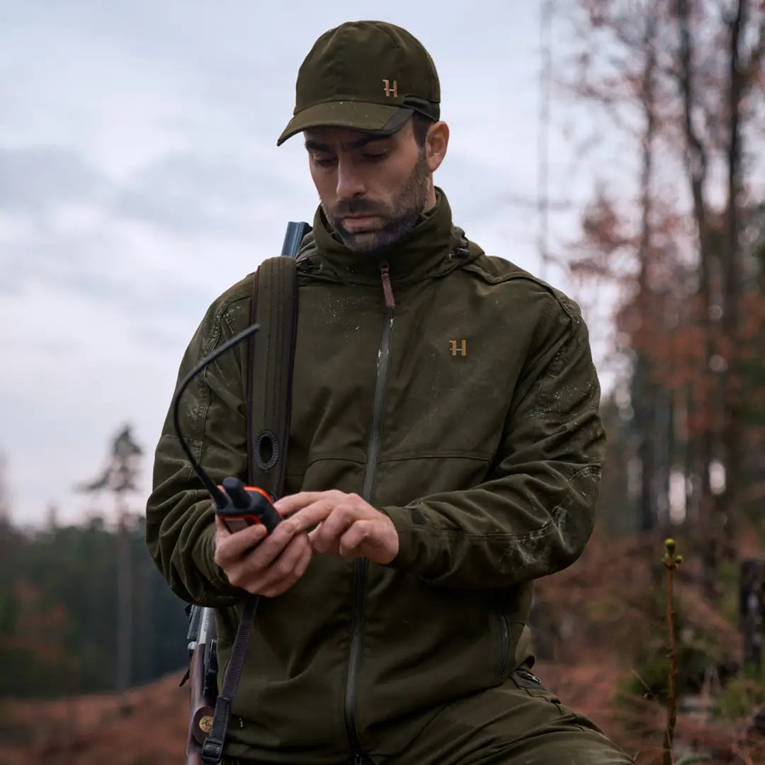 Man in Harkila Pro Hunter Move 2.0 GTX Jacket using mobile device outdoors