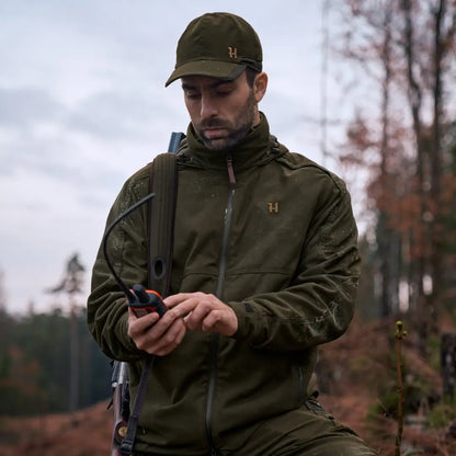 Man in Harkila Pro Hunter Move 2.0 GTX Jacket using mobile device outdoors