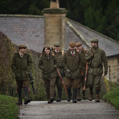 Group of people in traditional hunting attire featuring Harkila Pro Hunter Shooting Jacket