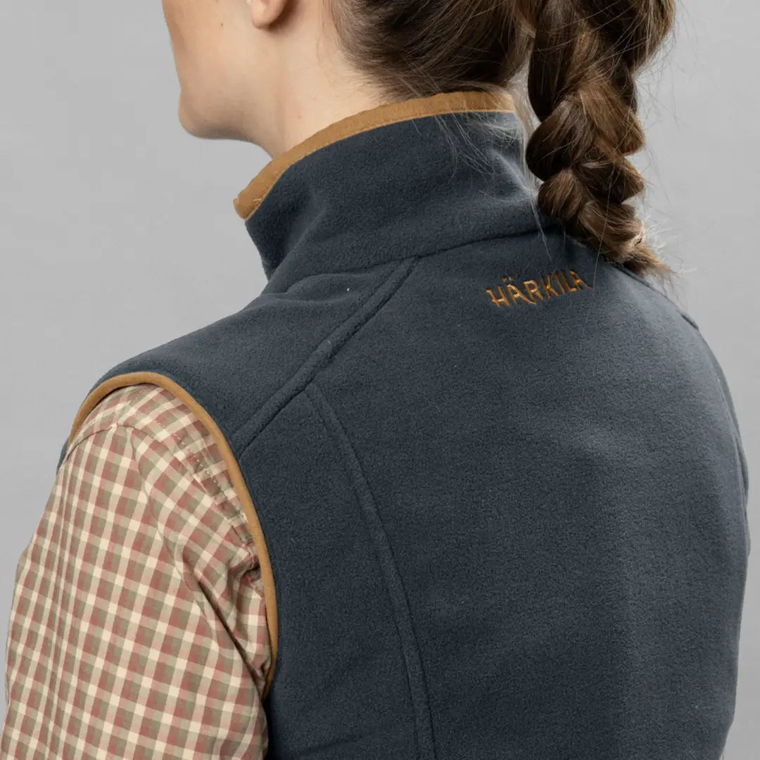 Dark gray Härkila vest over plaid shirt, stylish fit boasting wind-resistant check lining