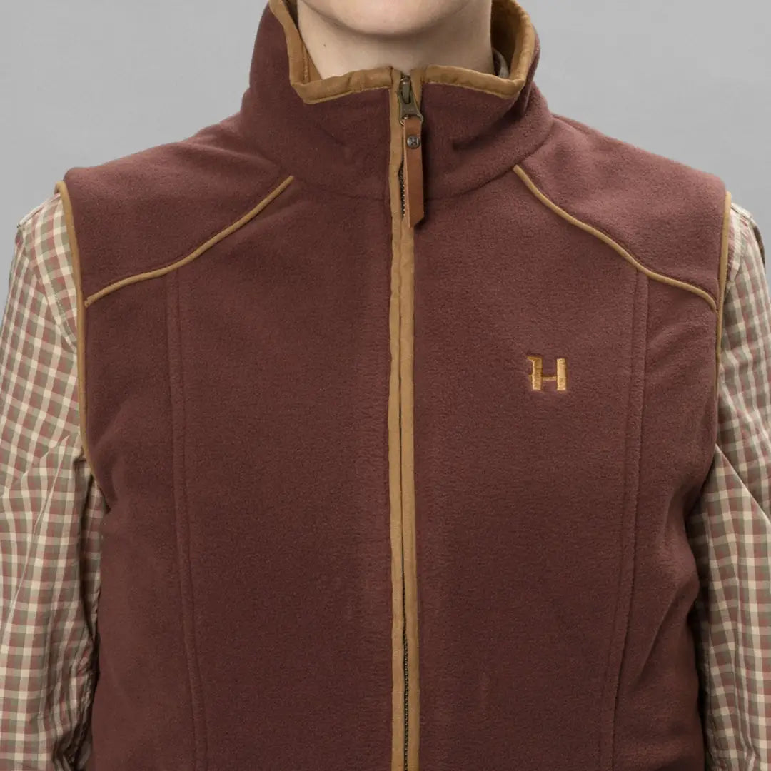 Burgundy fleece vest with tan trim and full-length zip, featuring leather pull and check lining