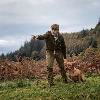 Man in traditional countryside attire pointing beside dog in Harkila Sandhem Pro Insulated Cardigan