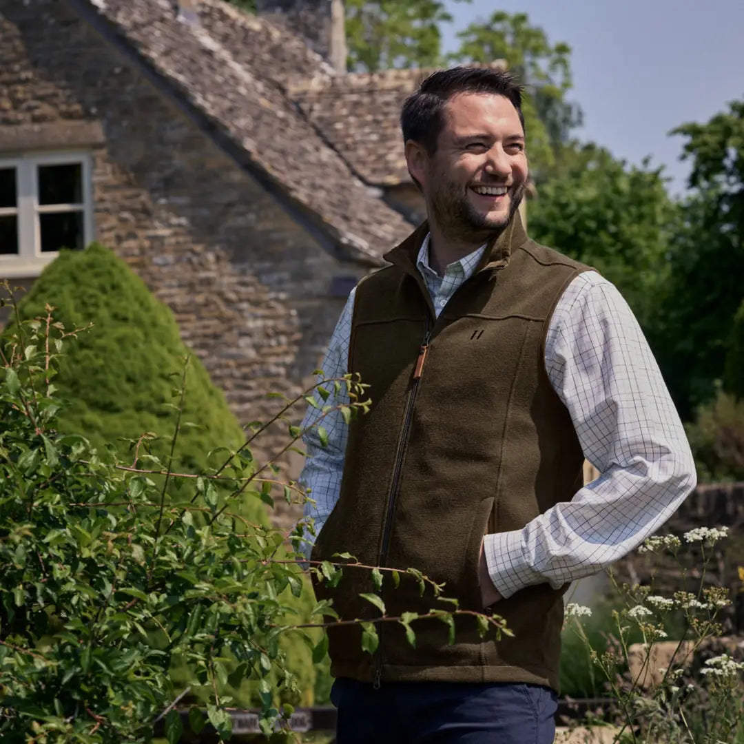 Smiling guy in a brown Harkila Sandhem Pro Waistcoat standing in a garden