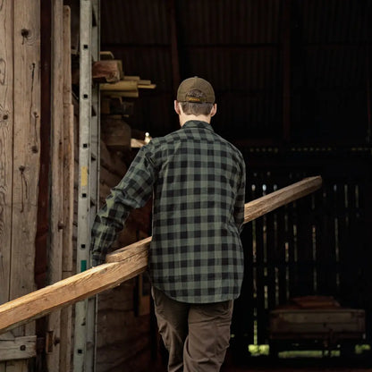 Person in a plaid shirt carrying a wooden board with Harkila Scandinavian Long Sleeve Shirt