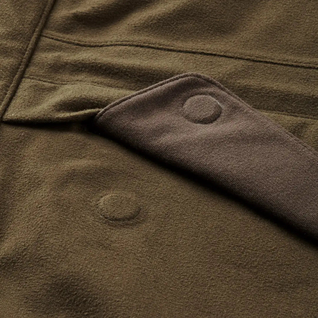 Close-up of olive green fabric with snap buttons on Harkila Visent winter hunting jacket