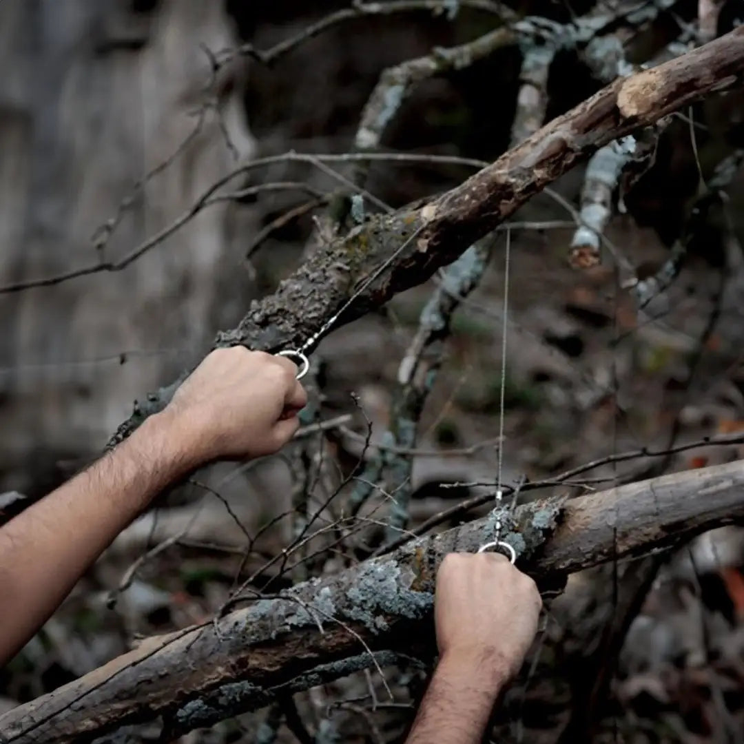 Hands gripping lichen-covered branches, perfect for country clothing and outdoor hunting adventures