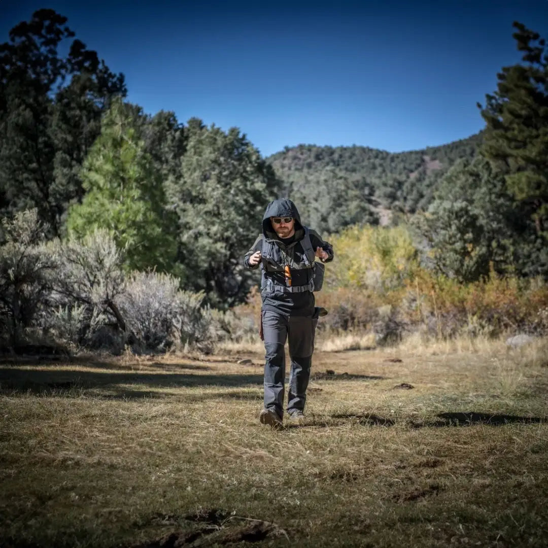 Person running in a grassy field wearing a Helikon-Tex Woodsman Anorak Jacket