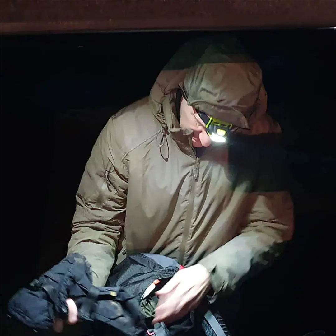 Person in a hooded jacket with a headlamp, showcasing Highlander Waterproof Mountain Hat