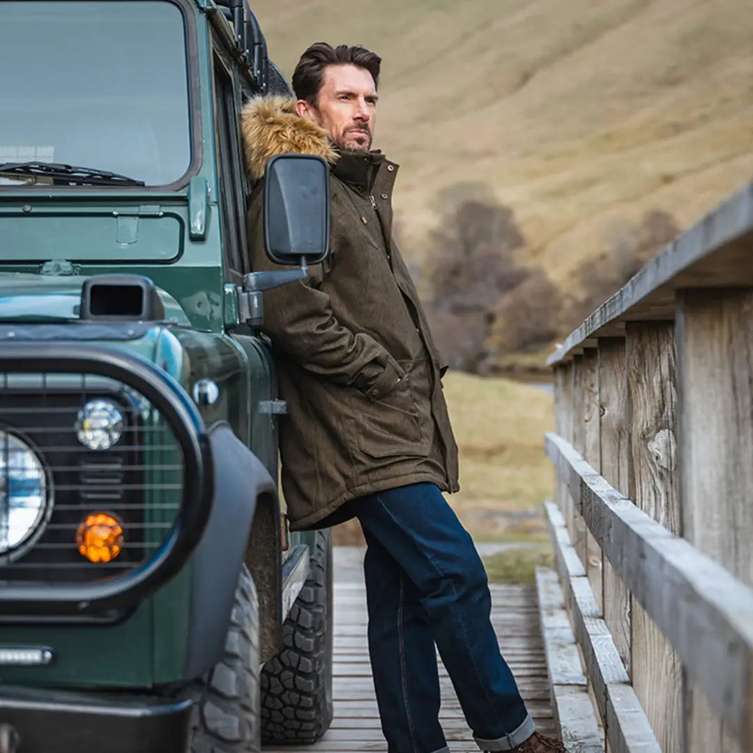 Man in a brown Hoggs of Fife Argyll II waterproof jacket by a green off-road vehicle