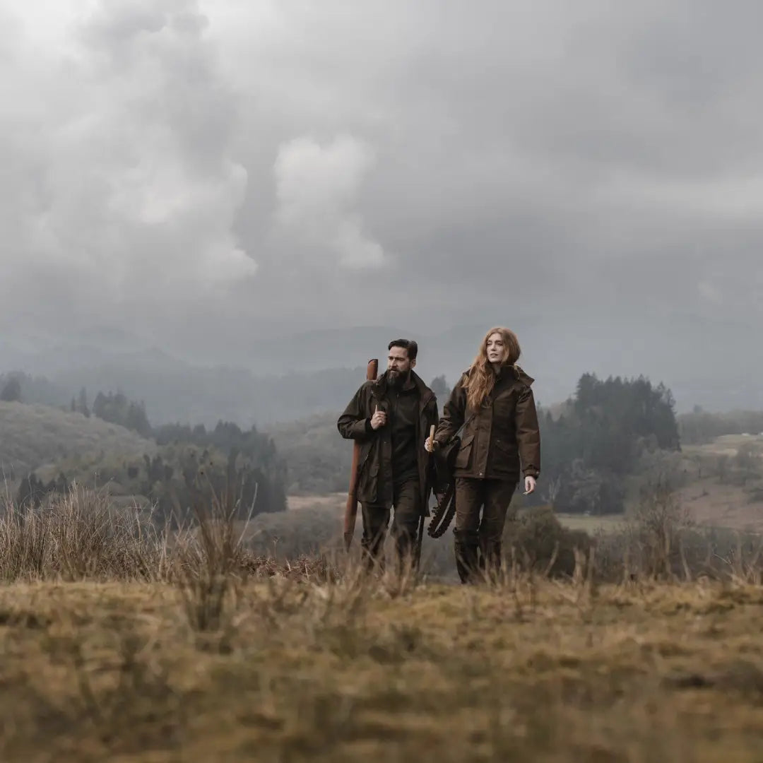 Two people wearing a Ballater Field Coat walking in an ideal Scottish Highland setting