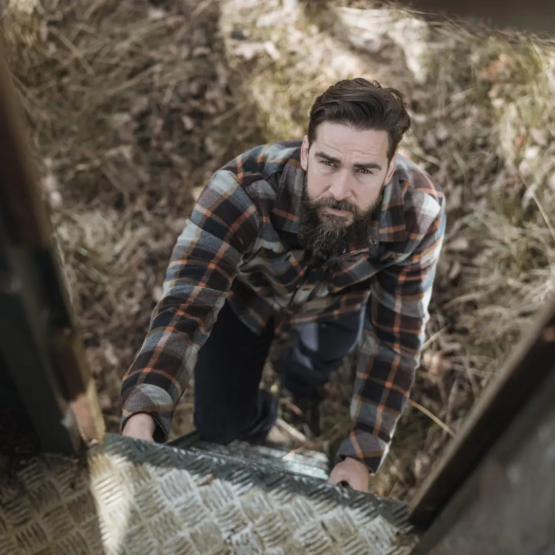 Bearded man in plaid shirt climbing stairs, showcasing Brucefield Fleece Shacket style