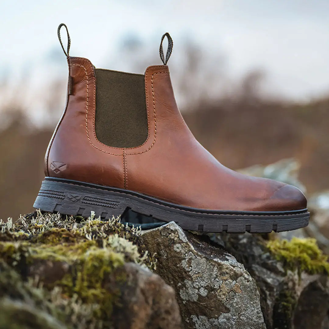 Brown leather Chelsea boot on mossy rocks, perfect for the Fife Dalmeny Dealer look