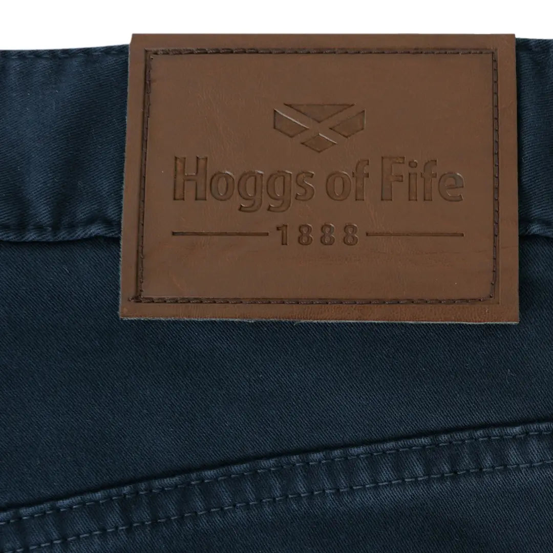 Leather label with Hoggs of Fife 1888 logo on dark fabric of Dingwall cotton stretch jeans