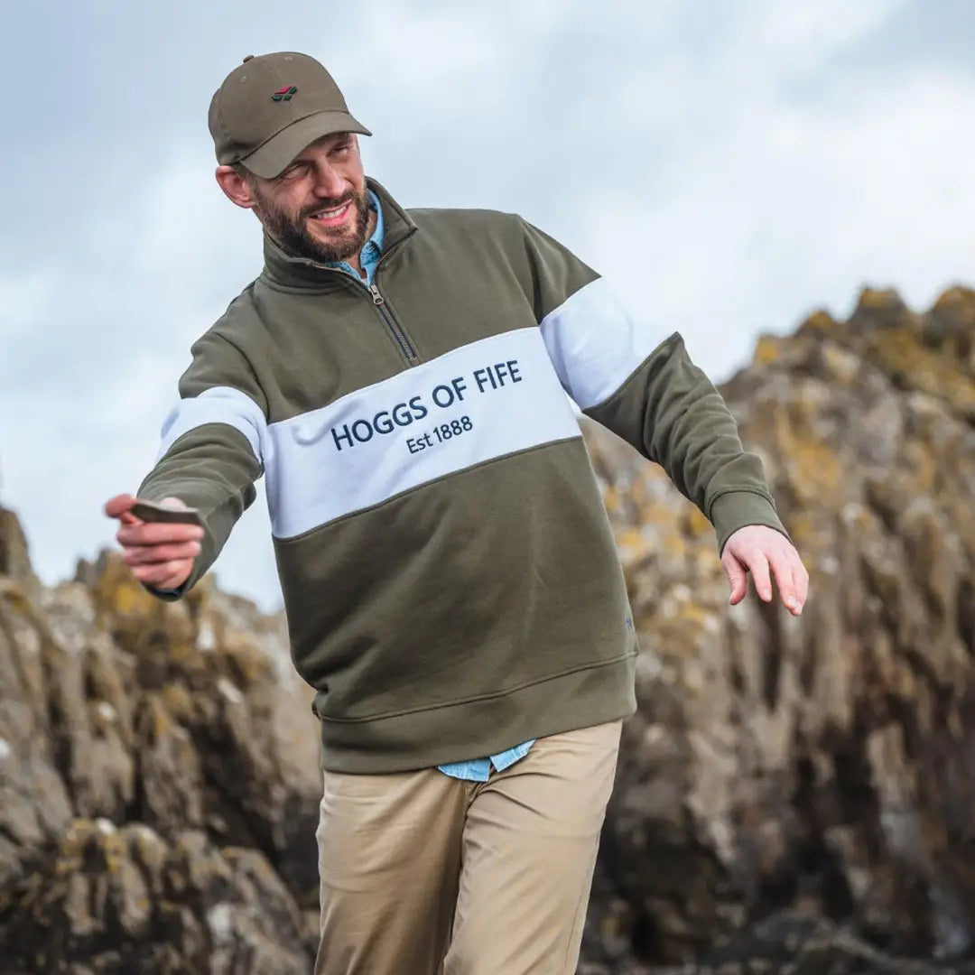 Bearded man rocking a Hoggs of Fife gents quarter zip sweatshirt and cap outdoors