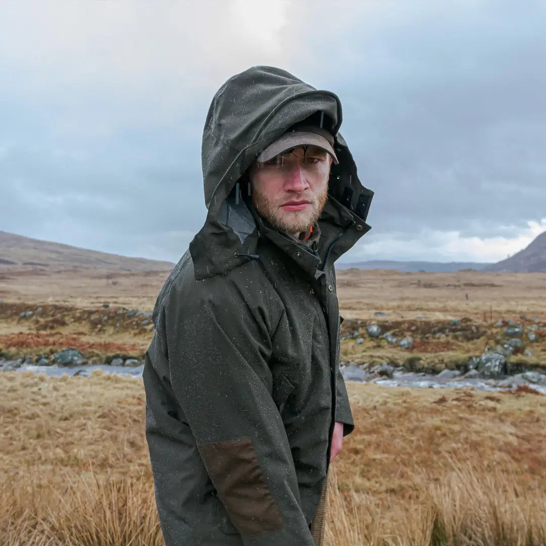 Man in a dark green hooded jacket in nature, sporting Fife’s best selling Green King II