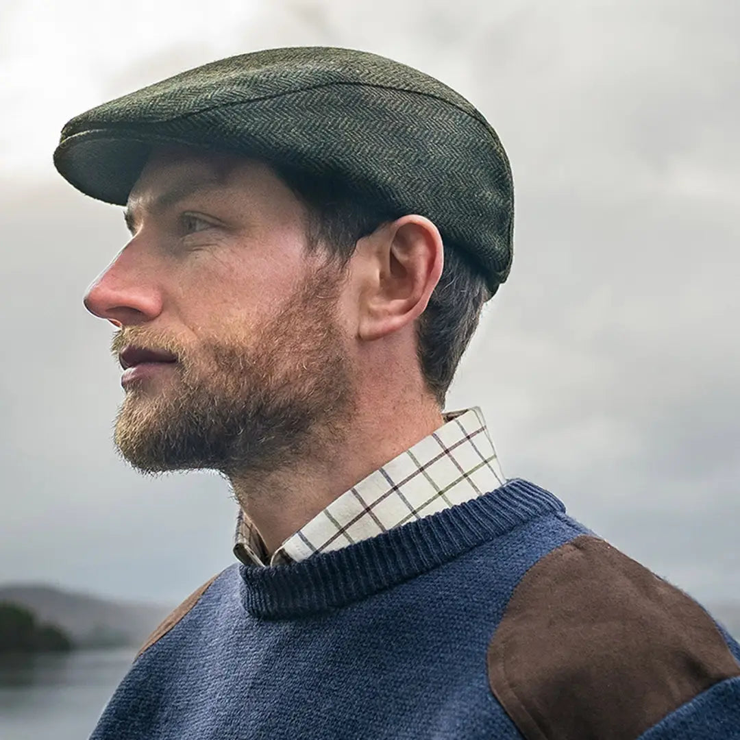 Man in profile wearing a Fife Herringbone Waterproof Tweed Cap and sweater with beard