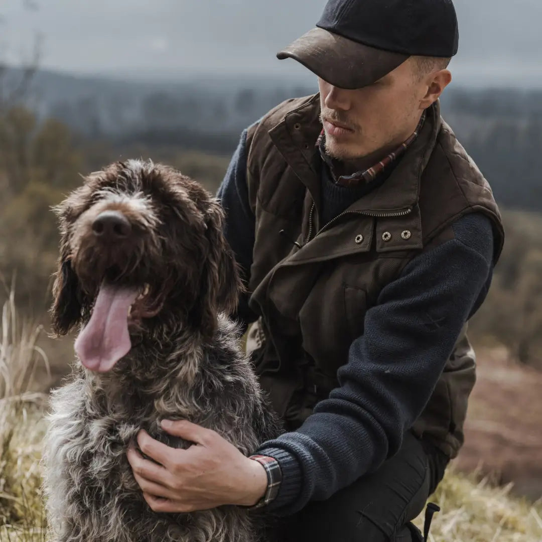 Shaggy brown dog with tongue out next to person in Hoggs of Fife Kincraig Field Waistcoat