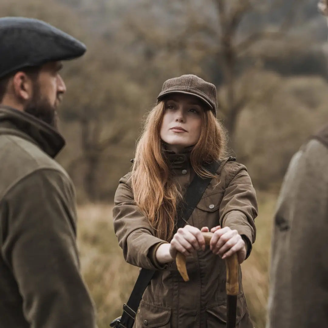 Woman in a brown cap and jacket, showcasing the Hoggs of Fife Rannoch Ladies Hunting Jacket