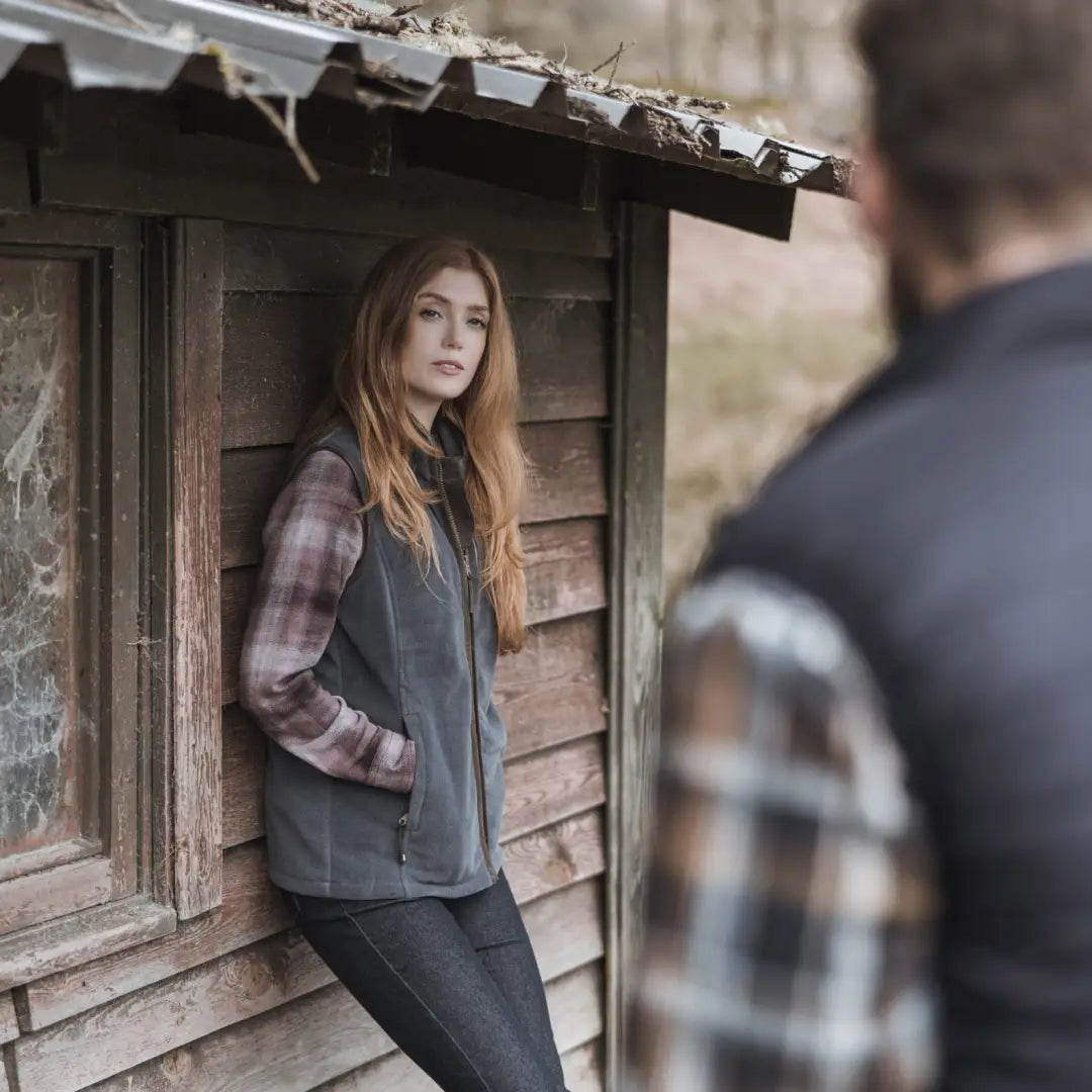 Young woman in plaid shirt and gray vest showcasing Stenton Ladies Fleece Gilet