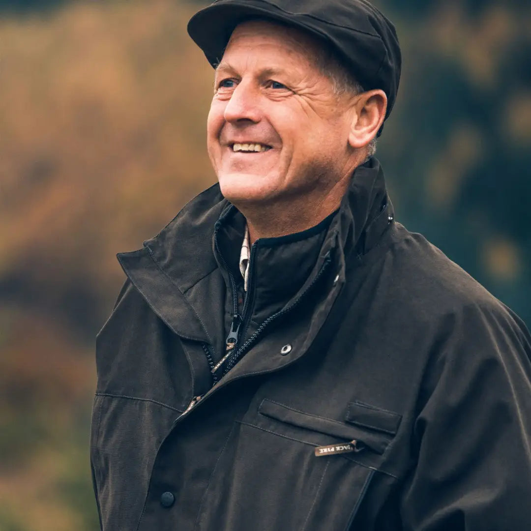 Smiling older man in a dark jacket and flat cap showcasing Jack Pyke Ashcombe