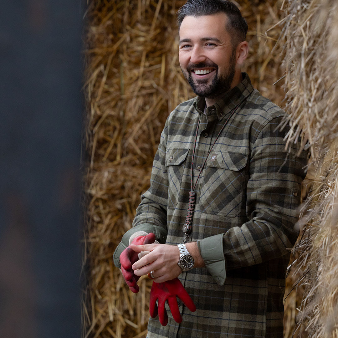 Smiling man wearing Jack Pyke Bleasdale Heavy Flannel Shirt in plaid design