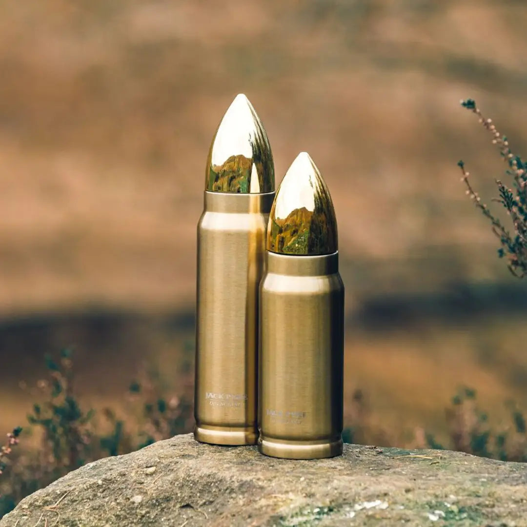 Two metallic bullets on a rock, showcasing the Jack Pyke Bullet Flask design