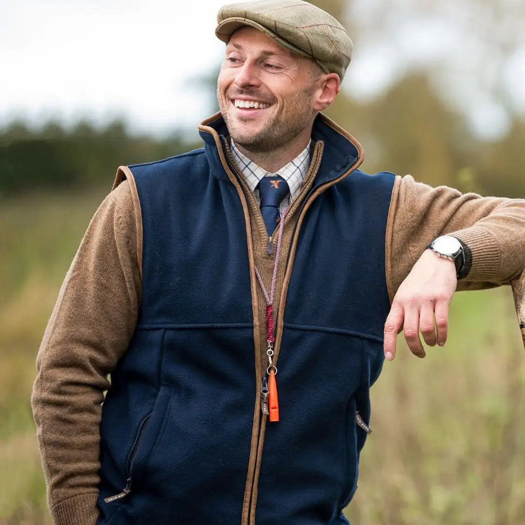 Smiling man in a flat cap and Jack Pyke Countryman Fleece Gilet in the countryside