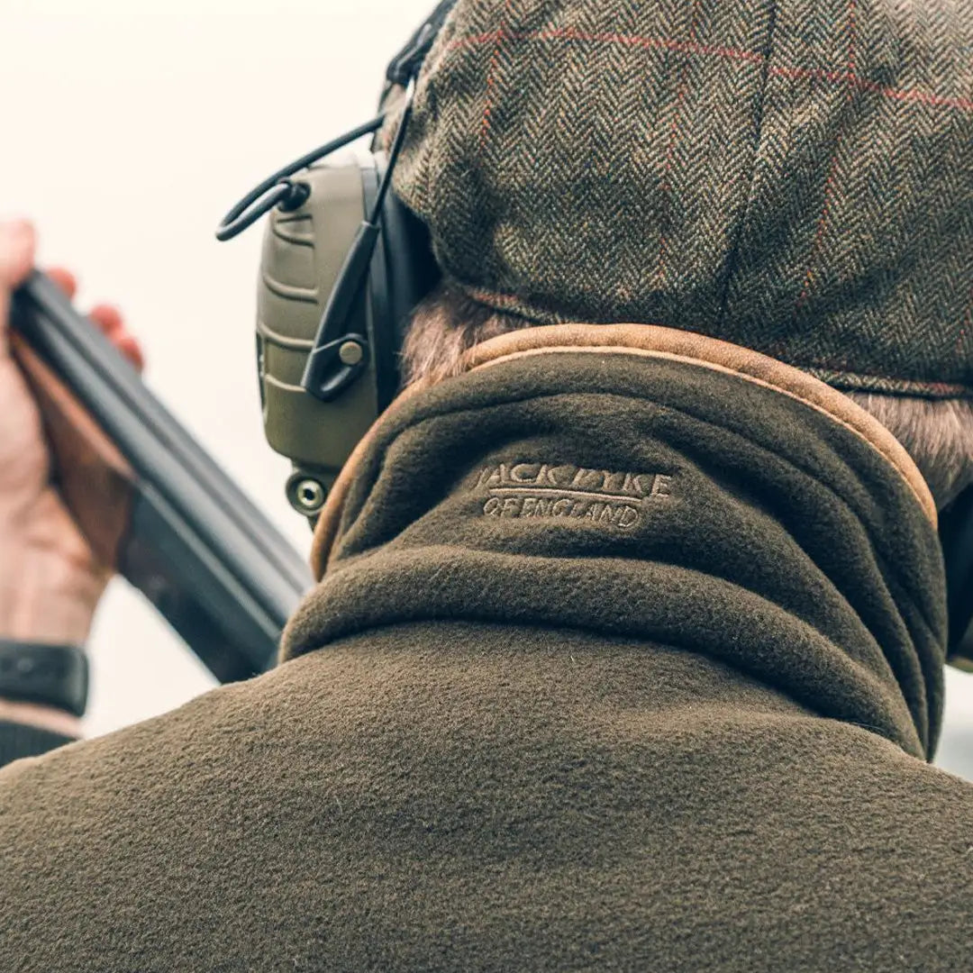 Jacket collar with Jack Pyke branding on a shooter holding a shotgun in the field