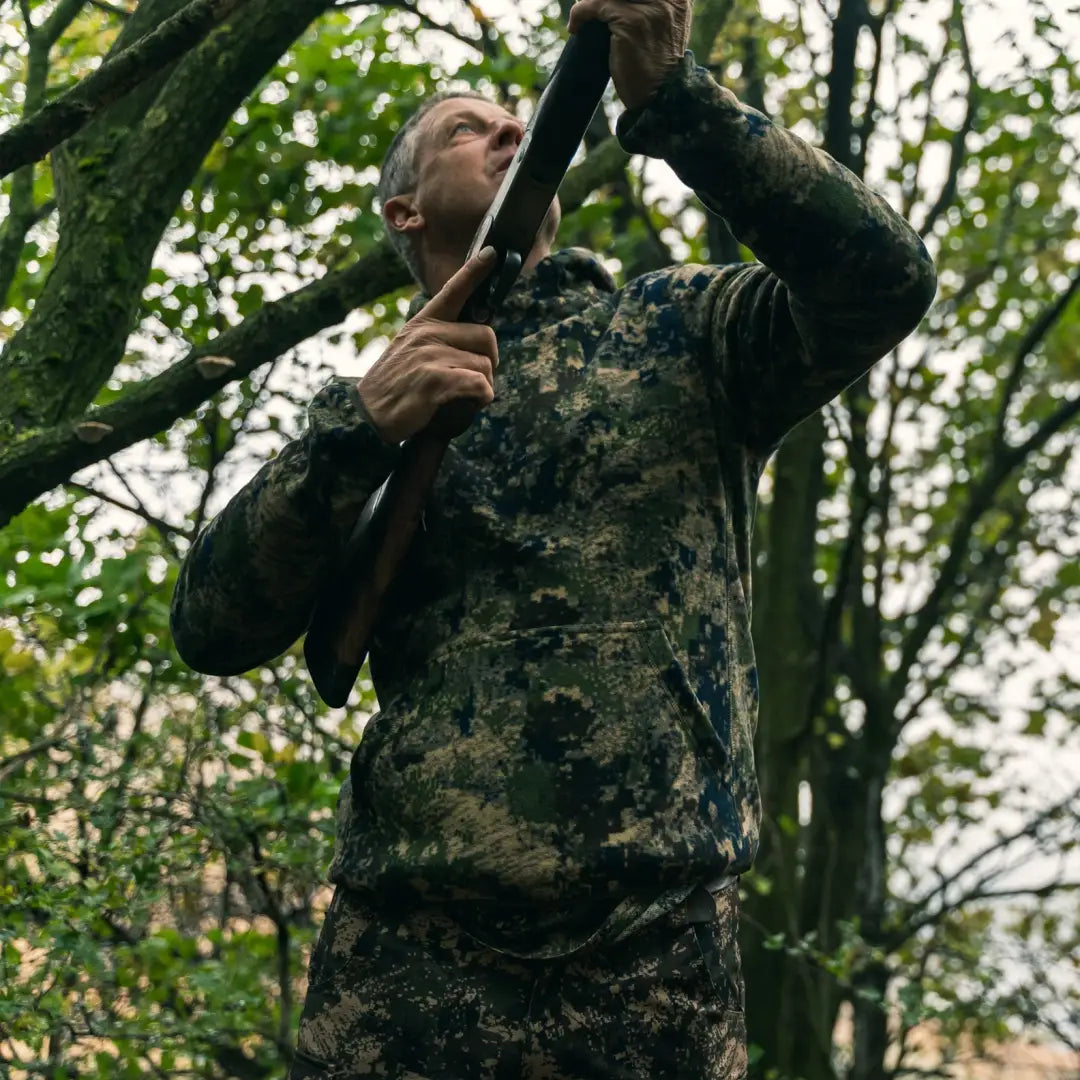 Person in Jack Pyke Fieldman Fleece Hoodie using binoculars in a forest