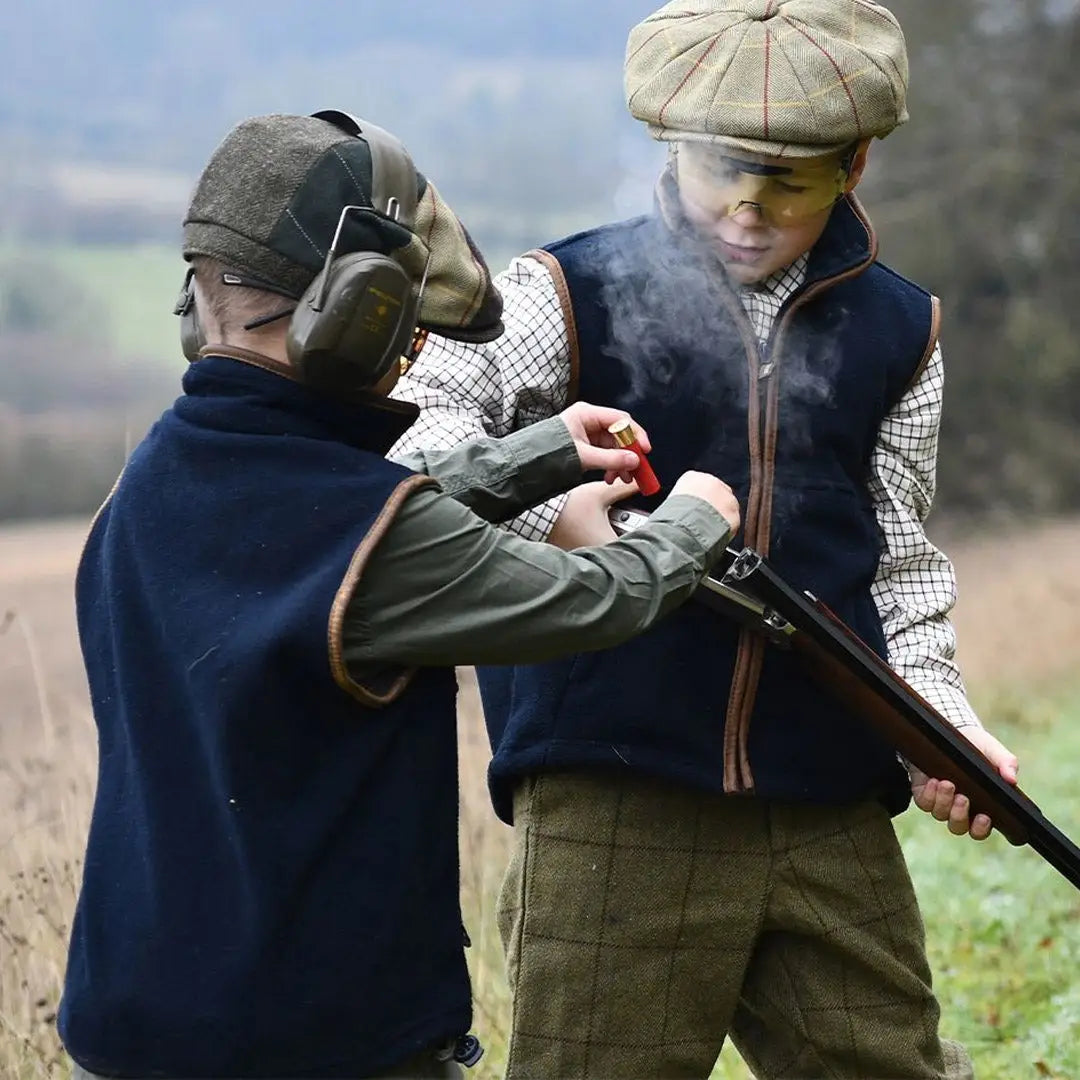 Two hunters in traditional attire loading a shotgun with Jack Pyke Junior Countryman Fleece Gilet