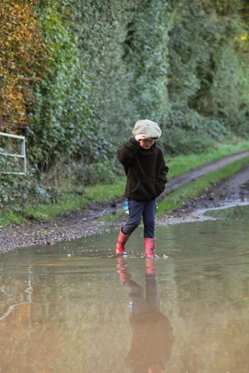 Child in red boots wading while wearing Jack Pyke Junior Sherpa Fleece Hoodie