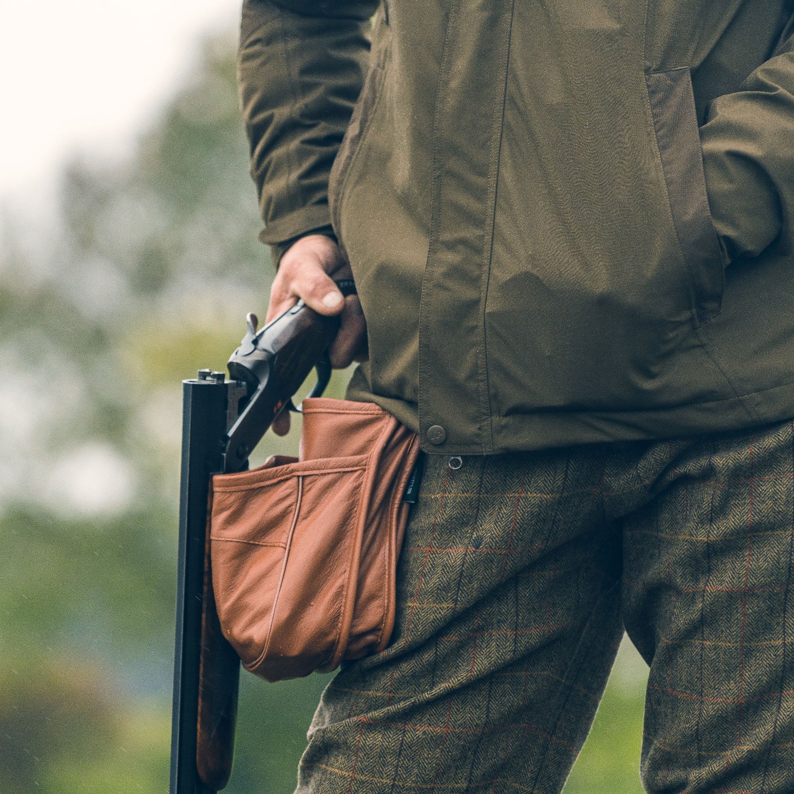 Hunter with a shotgun showcasing Jack Pyke Leather Cartridge Pouch in action