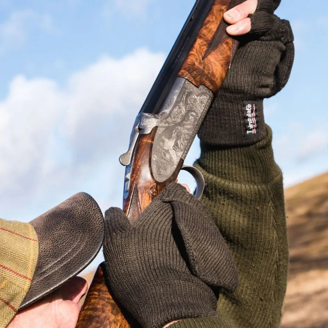 Double-barreled shotgun with ornate stock next to Jack Pyke Shooters Mitt