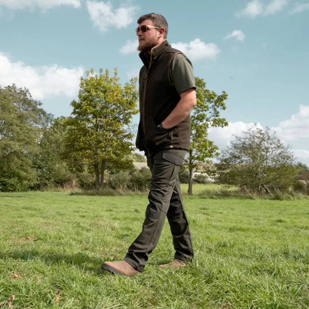 Man in casual outdoor gear walks in Jack Pyke Softshell Trouser with press stud cargo