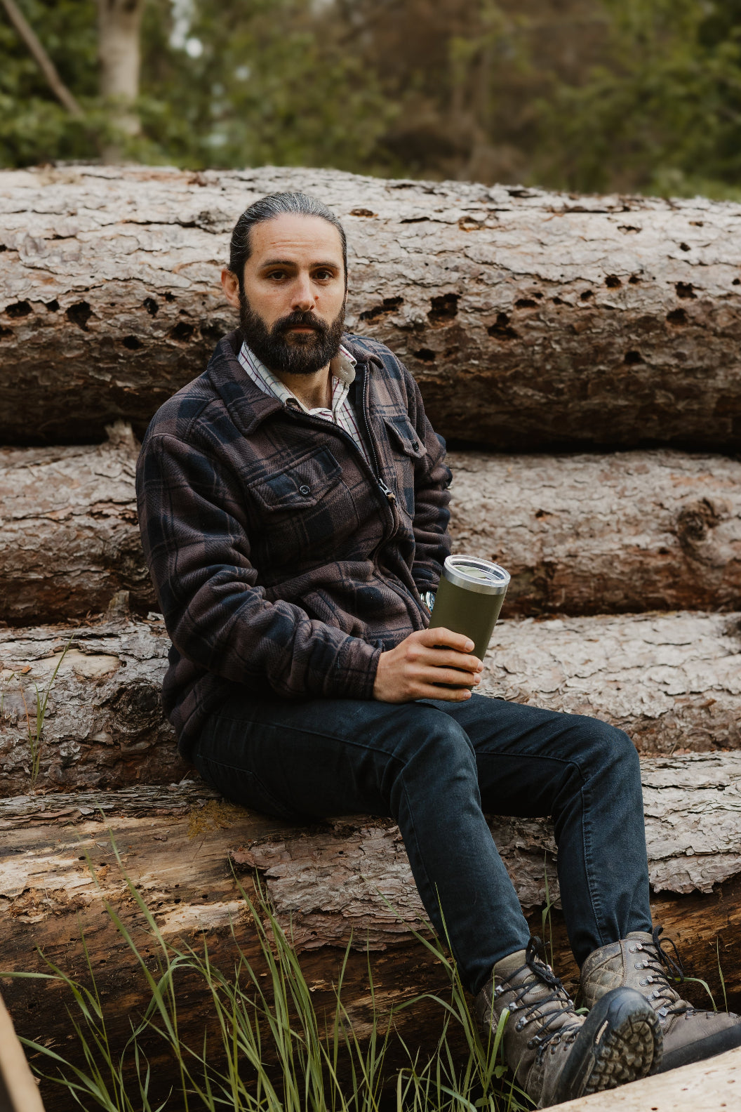 Man on logs enjoying a drink while wearing the Jack Pyke Tundra Shirt