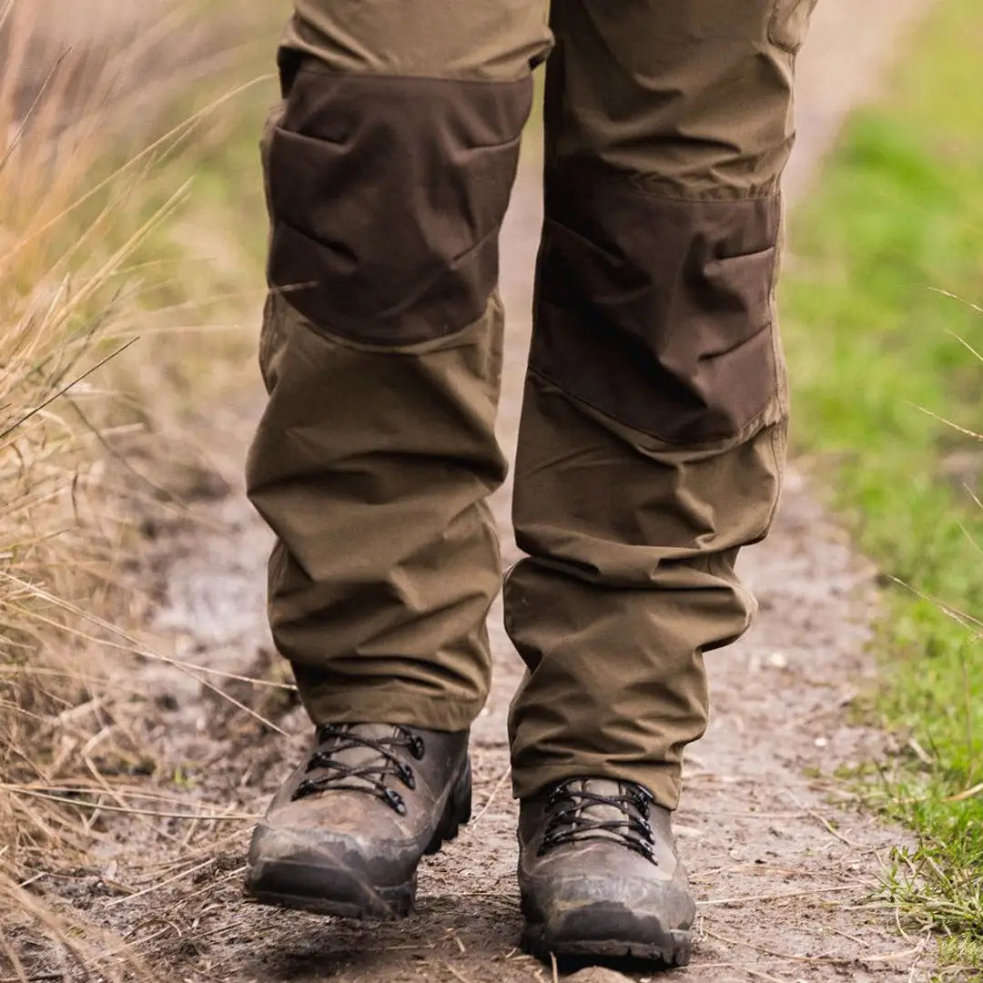 Pair of rugged hiking boots with Jack Pyke Weardale trousers on a dirt path